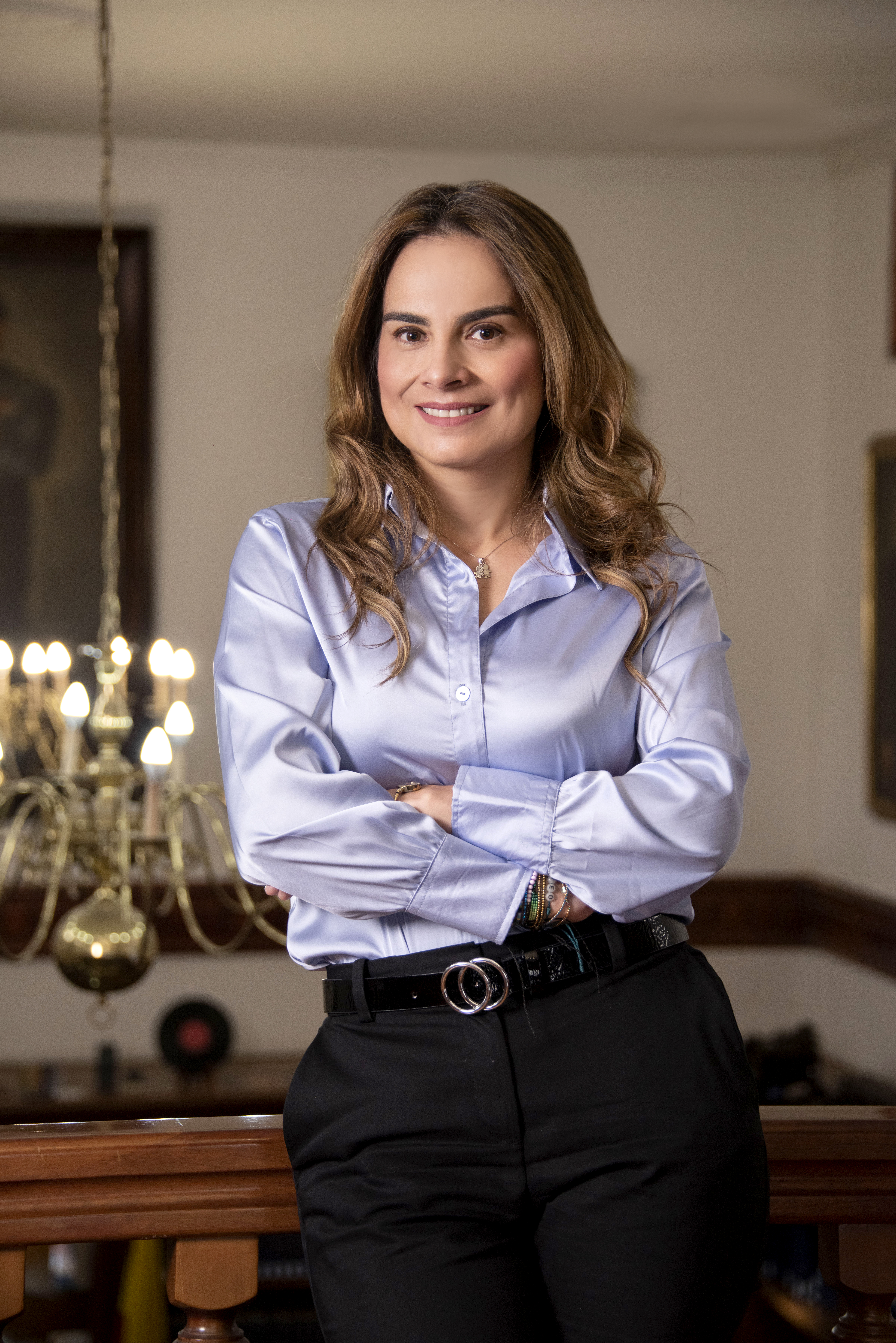 Neried Echeverry Prada en un interior cálido, con camisa azul claro y los brazos cruzados